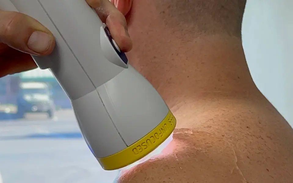 SoftWave applicator treating the back of a patient’s neck